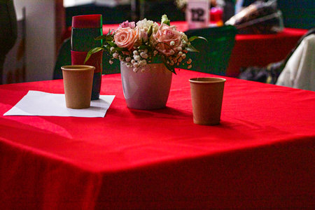 delicate bouquet of roses in a vase on a red tableclothの写真素材