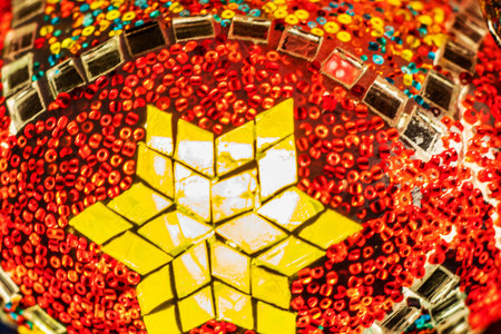 stained glass lamp on a dark background with a geometric pattern in red shades