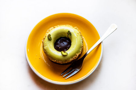dessert Dubai tart with pistachio cream on a yellow plate,