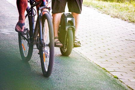 cyclist and a hoverboard are riding on a track in a parkの写真素材