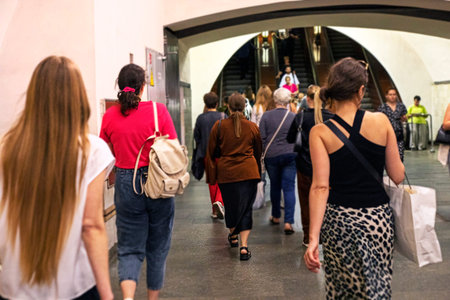 crowd of people during rush hour is about to leave the subway escalator