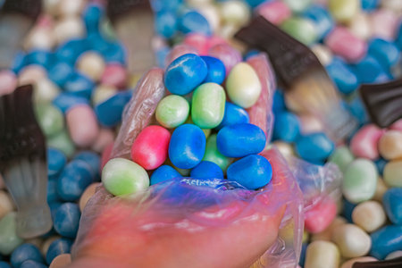 picking up jelly candies with a hand in a disposable glove for purchase