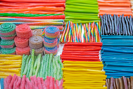 jelly candies with different flavors in the forms of multi-colored sticks or worms in a confectioneryの写真素材