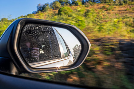 photographing through the right mirror of the car. Traveling by car