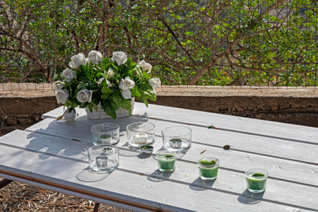 bouquet of white flowers with candlesticks on a table in the garden during the day