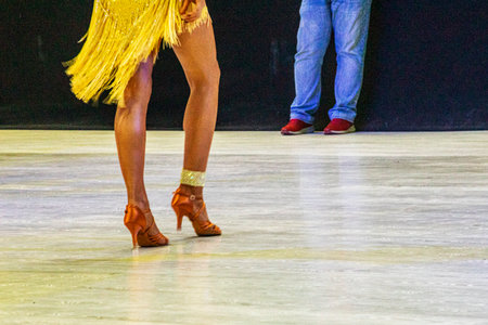 young dancer in a yellow dress performs a Latin American routine on the floor.の写真素材