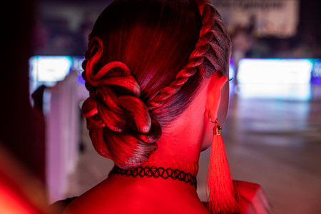 young dancer's beautiful bun hairstyle for a dance tournament with red earrings.の写真素材