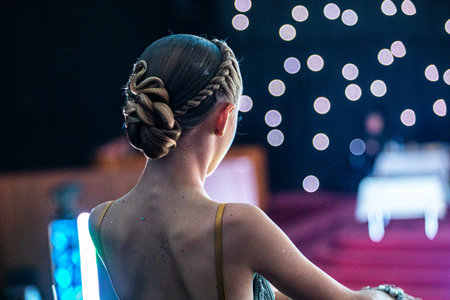 back of a young dancer's beautiful curled hairstyle at a tournament