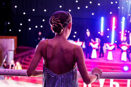 young dancer in a Latin American dress watches a dance tournament from above.の写真素材