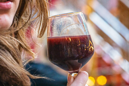 Drinking hot punch from a glass at a street fair.