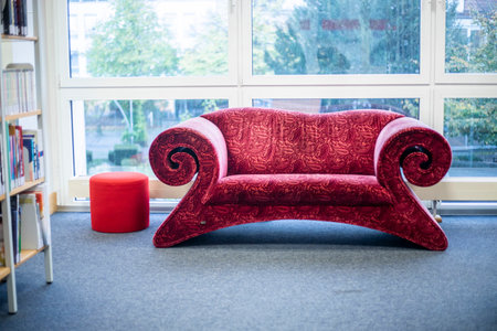 beautiful red sofa in a public library on a cloudy dayの写真素材