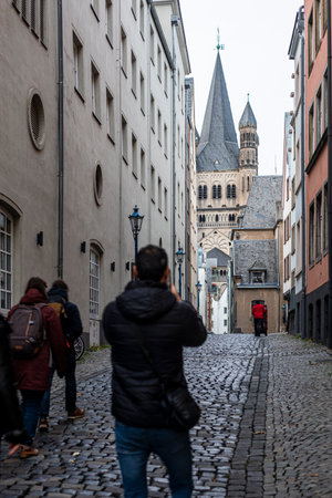 Beautiful view of the famous Cologne Cathedral from a narrow street in Cologne on a cloudy eveningの写真素材