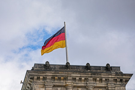 German flags in cloudy weather at the seat of the German parliamentの写真素材