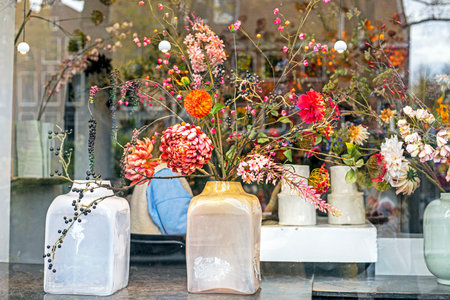 beautiful bouquet of flowers in a ceramic vase by the windowの写真素材