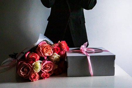 pink bouquet with roses next to a festive pink cake on a light background.の写真素材