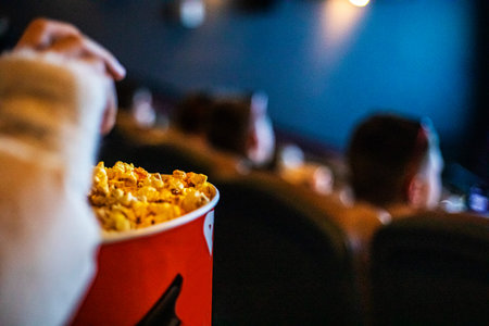 Eating popcorn while watching a movie at the cinema