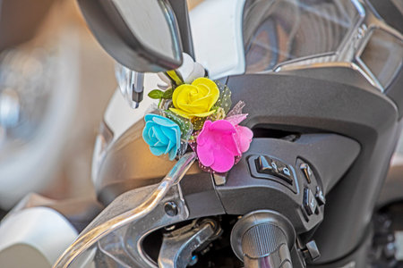 small flower bouquet attached to a motorcycle handlebar.の写真素材