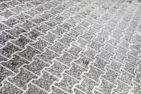 Smeared street tiles dusted with snow