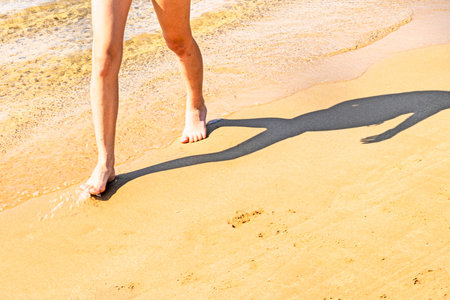 Women's feet walking on wet sand on the beach. Joint and skin healthの写真素材