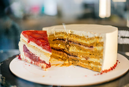 A slice of fruit cheesecake and half a puff pastry cake on a plate