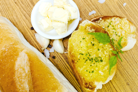 Garlic bread with ingredients on a wooden plate の写真素材