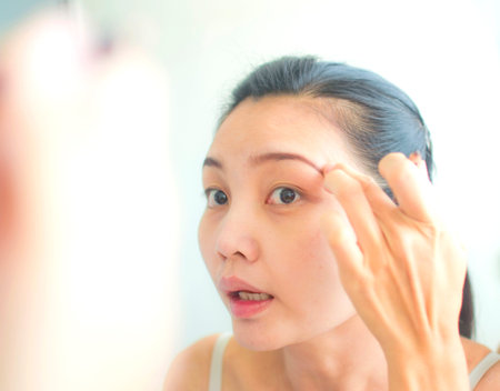 Asian women making up eyebrow
