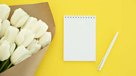 white tulips flowers on yellow background Place for text. postcard. holiday. Women's Day. Valentine's Day. mother's dayの写真素材