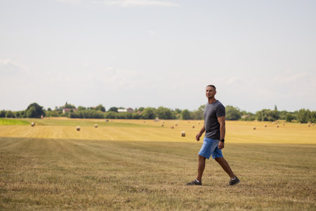 A man walks through an agricultural field.の写真素材