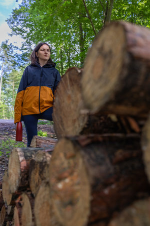 Woman tourist standing on tree logs in the forest.の写真素材