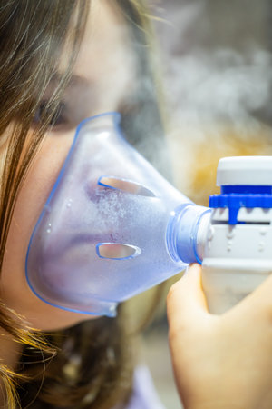 Child using nebulizer for asthma treatment at home during daytime