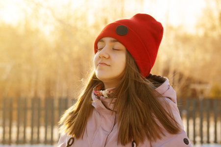 Free happy young girl in a red hat, enjoying nature. Beautiful European girl outdoors. The concept...