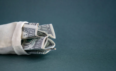 Canvas bag with cash close-up on an isolated gray-green background. Concept of saving, saving money,...