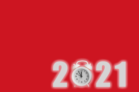 New year 2021 creative design concept with alarm clock. White numbers and an alarm clock on a red...