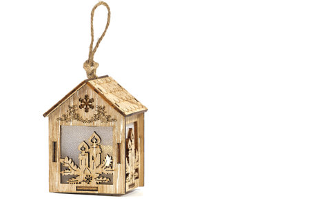 Christmas tree decoration made of natural material, wooden carved house, on a white isolated...
