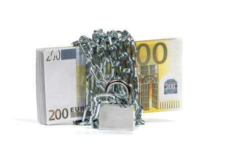 A bundle of 200 Euro banknotes is wrapped with a metal chain with a lock. The concept of money savings. Selective focus, close-up, white isolated background with soft shadow.の写真素材
