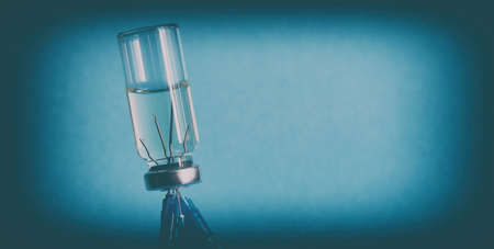 The concept of vaccination. Close-up, banner. An ampoule of medicine, turned upside down, and five medical needles from syringes stuck in the bottle cap.の写真素材