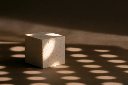 3d podium, for presentations of packaging and cosmetics. Beige foam cube against background of brown...
