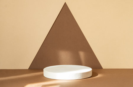 Round wooden stand for displaying goods on abstract brown-beige background. Concept of 3d podium for presentation of cosmetic products. Geometric pedestal for demonstrations.の写真素材