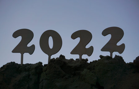 Welcome to year 2022. Silhouette of wooden figures against night sky. Concept of waiting for happy New Year.の写真素材