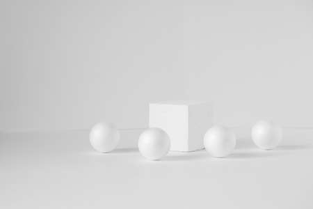 Geometric composition of a cube and balls on an isolated white background. Concept of 3d podium for presentations of packaging and cosmetics. Close up, copy spaceの写真素材