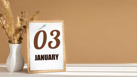 january 3. 3th day of month, calendar date.White vase with dead wood next to cork board with numbers. White-beige background with striped shadow. Concept of day of year, time planner, winter month.の写真素材