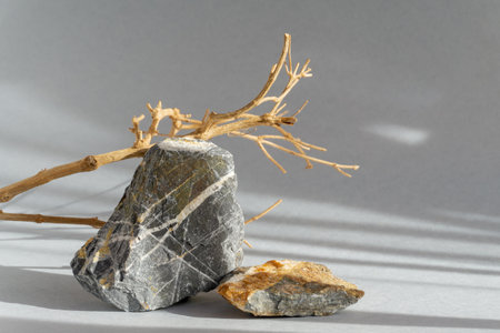 Sand for cosmetic products made of natural marble stone on gray background. 3D podium for demonstration of various goods in rays of sunlight with shadows.の写真素材