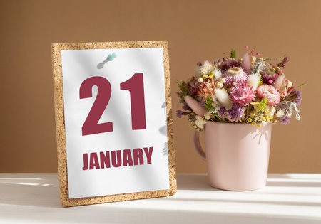 january 21. 21th day of month, calendar date.Bouquet of dead wood in pink mug on desktop.Cork board with calendar sheet on white-beige background. Concept of day of year, time planner, winter month.の写真素材