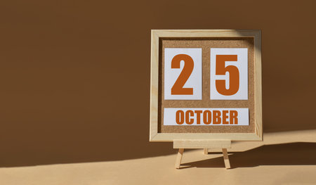 October 25th. Day 25 of month, Calendar date. Cork board, easel in sunlight on desktop. Close-up, brown background. Autumn month, day of year concept.の写真素材