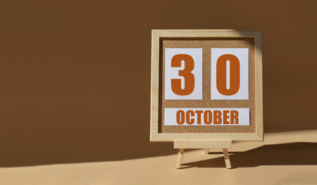 October 30th. Day 30 of month, Calendar date. Cork board, easel in sunlight on desktop. Close-up, brown background. Autumn month, day of year concept.の写真素材