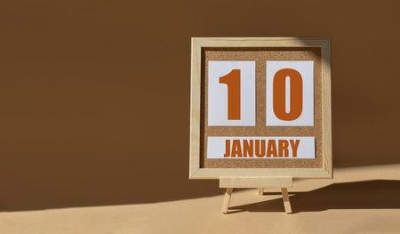 January 10th. Day 10 of month, Calendar date. Cork board, easel in sunlight on desktop. Close-up, brown background. Winter month, day of year concept.の写真素材