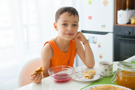 Little boy having breakfast in the kitchenの写真素材