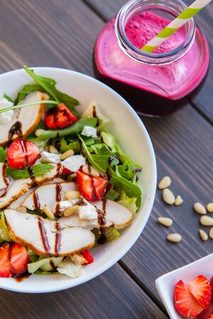Strawberries salad with pine nuts, arugula and chicken.の写真素材