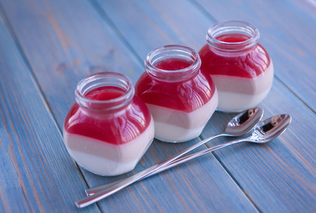 Panna cotta dessert with strawberry jelly on rustic wooden background.の写真素材