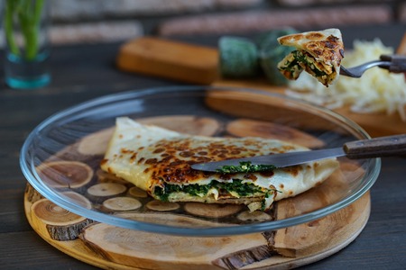 Pancakes filled with spinach and cheese on the wooden surface. Pancake week.の写真素材